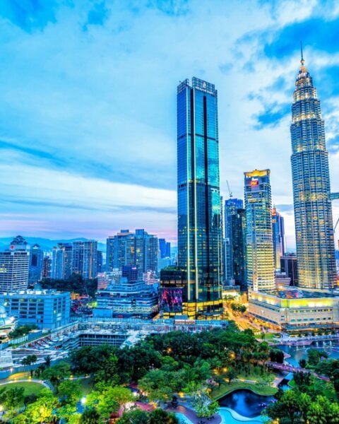 The Petronas Twin Towers rise majestically in the background of a vibrant Kuala Lumpur skyline, symbolising Malaysia Construction Safety Standards.