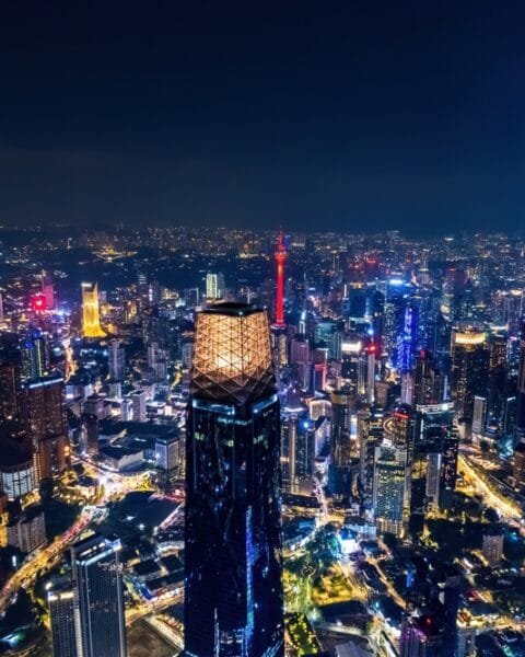 A nighttime aerial view of a brightly lit Kuala Lumpur cityscape with dense skyscrapers, indicating the Public-Private Partnerships Malaysia.