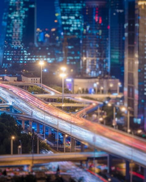 Smart City Projects Malaysia: A blurred cityscape at twilight with illuminated streets and dynamic traffic light trails.